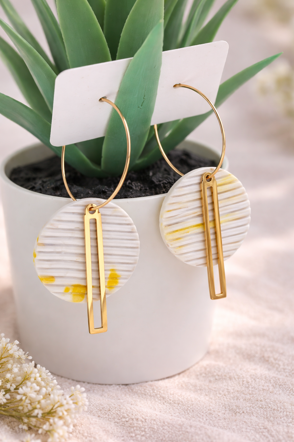 Handgemachte vergoldete Creolen mit rundem Polymer-Clay-Anhänger auf Schmuckständer