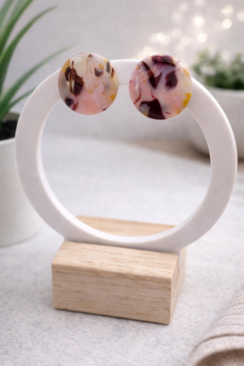 Handgemachte runde Ohrstecker aus Polymer Clay in Beige, Bordeaux und Senfgelb auf modernem Schmuckständer