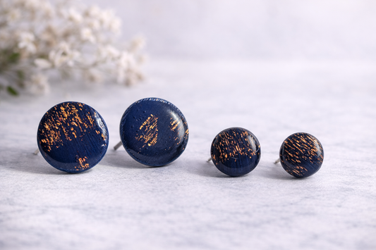 Marineblaue runde Ohrstecker aus Polymer Clay mit goldenen Akzenten, handgefertigt, getragen am Ohr