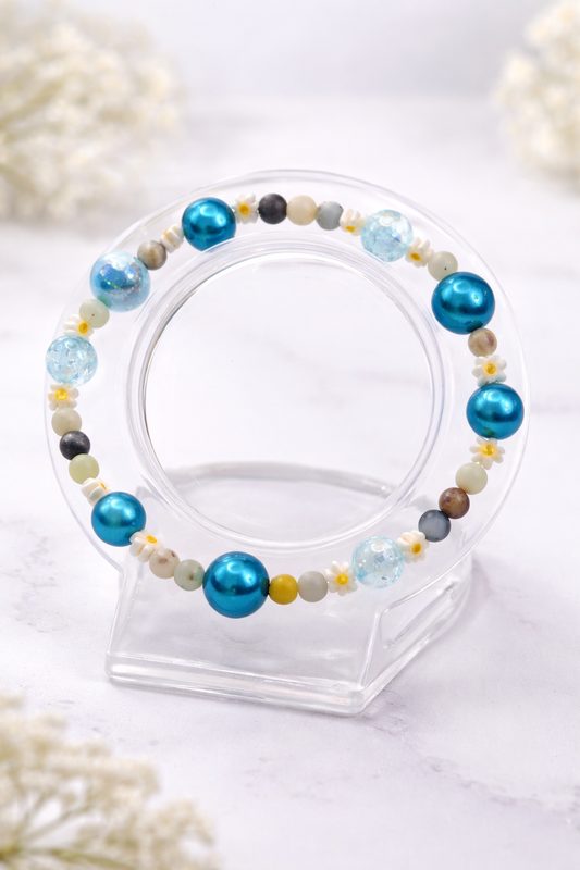 Handgemachtes blaues Armband mit Glanzperlen und kleinen weißen Blüten