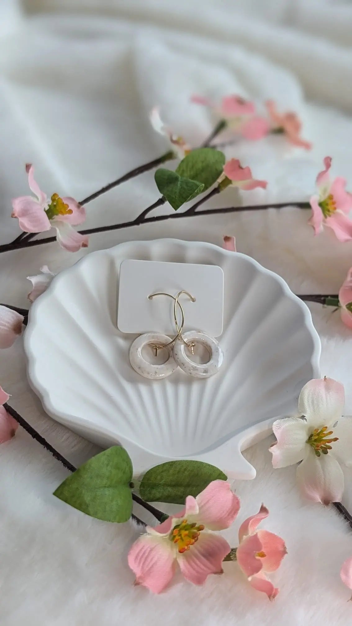 Handgemachte Boho-Creolen mit weiß marmoriertem Ring aus Polymer Clay auf hellem Hintergrund