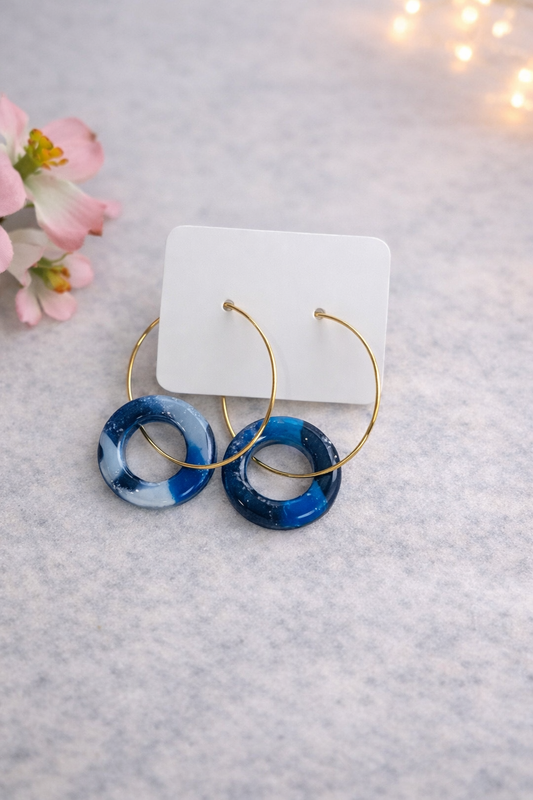 Handgemachte Boho-Creolen mit blau marmoriertem Ring aus Polymer Clay auf hellem Hintergrund