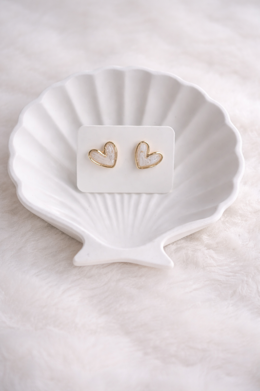 Zarte Herz-Ohrstecker aus Polymer Clay in Weiß mit goldener Umrandung, getragen von einer Frau – minimalistisch und elegant.