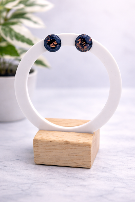 Marineblaue runde Ohrstecker aus Polymer Clay mit goldenen Akzenten, handgefertigt, getragen am Ohr