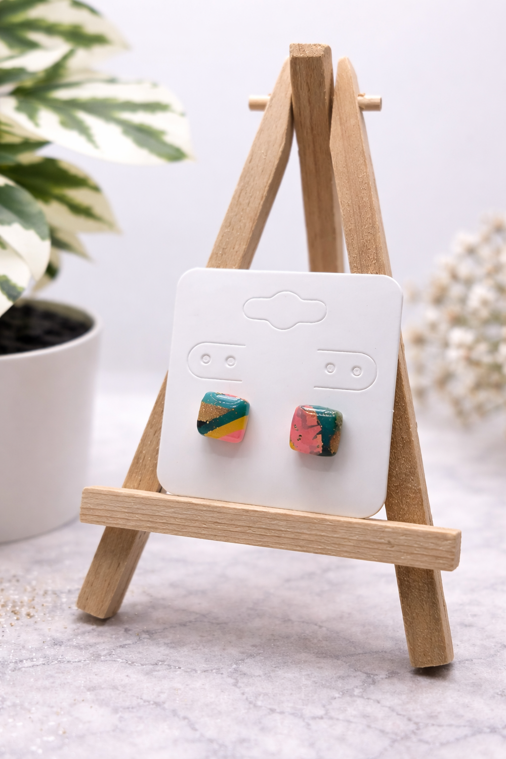 Quadratische Ohrstecker aus Polymer Clay am Ohr einer Frau