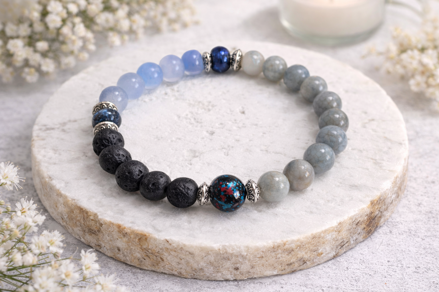 Lavastein Perlenarmband in Blau und Grau mit Glasperle auf hellem Hintergrund