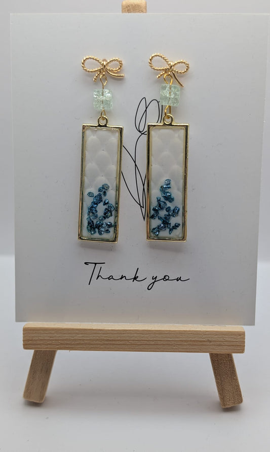 Elegante handgefertigte Ohrringe mit Goldrahmen und blauen Steinchen